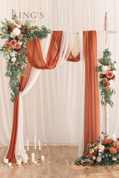 the wedding arch is decorated with orange and white flowers, greenery, and candles