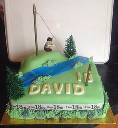 a birthday cake with a fishing theme on it's side and the name david written in gold