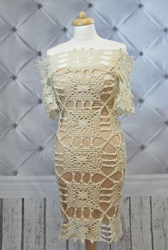 a dress on a mannequin with an off the shoulder top and crocheted lace