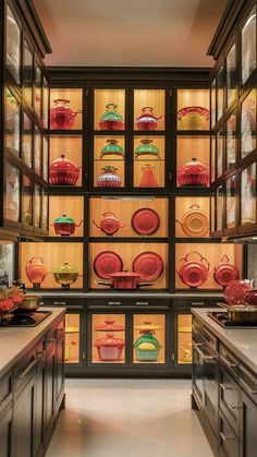 a kitchen filled with lots of red and green glassware on display in the cabinets