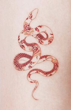 a snake tattoo on the back of a woman's stomach, with red ink