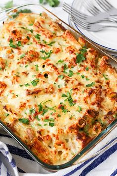 a casserole dish with cheese and vegetables in it on a blue and white towel