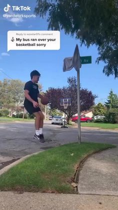 a man in black shirt and shorts playing basketball on street corner with sign that says, my bus ran over your basketball sorry