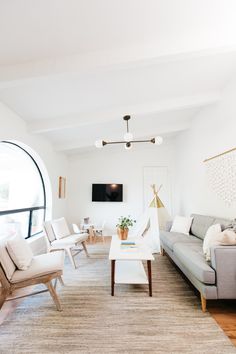 a living room filled with furniture and a flat screen tv mounted to the side of a wall