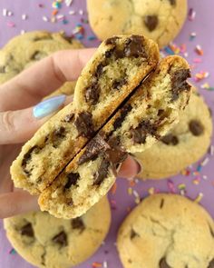 a person holding up a chocolate chip cookie