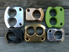 four different types of metal parts sitting on top of a wooden table