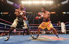 two professional boxers in the ring during a boxing match, one is wearing yellow shorts