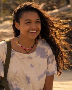 a woman with long hair is smiling at the camera