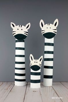 two zebras and a cat made out of toilet paper rolls on top of a wooden table