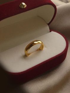 a gold ring in a red velvet box