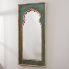 a mirror hanging on the wall next to a white wall with a shadow cast onto it