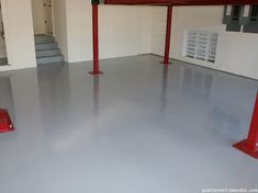 an empty garage with two red poles on the floor