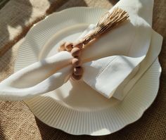 a white plate topped with two napkins and a wooden stick on top of it