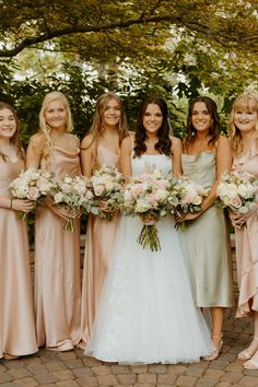 a group of women standing next to each other holding bouquets