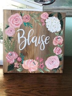 a wooden sign with flowers painted on it that says,'blasee '