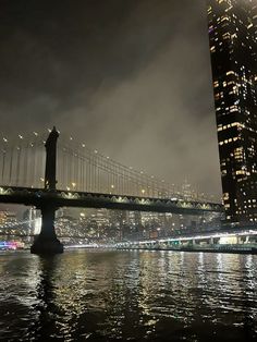 the city skyline is lit up at night with lights reflecting in the water and skyscrapers