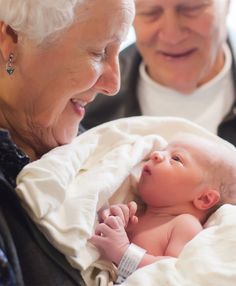 an older woman holding a baby in her arms