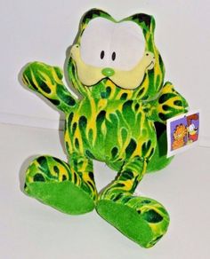 a green and yellow frog stuffed animal on a white surface