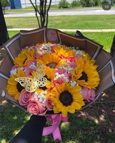 a bouquet of sunflowers, roses and other flowers in someone's hand