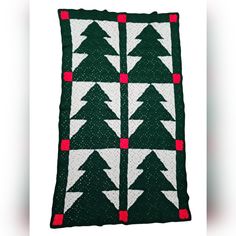 a green and white christmas tree quilt with red dots on the bottom, in front of a white background