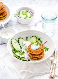 a white plate topped with cucumbers and other food on top of a table