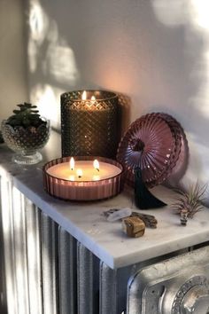 two candles sitting on top of a radiator next to an air conditioner