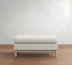 a white bench sitting on top of a hard wood floor