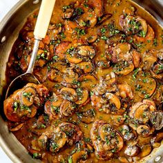 a pan filled with shrimp and mushrooms covered in gravy