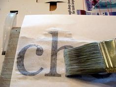 a paintbrush sitting on top of a piece of paper with the letter c in it