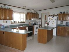 a kitchen with wooden cabinets and stainless steel counter tops, along with an island in the middle