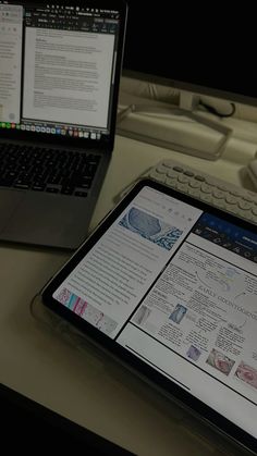 a tablet computer sitting on top of a desk next to a keyboard and laptop computer