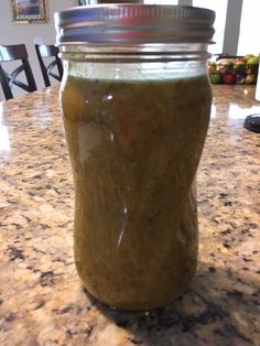 a jar filled with green liquid sitting on top of a counter