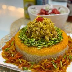 an elaborately decorated cake sitting on top of a plate next to a bowl of fruit