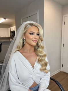 a woman sitting in a chair wearing a wedding veil