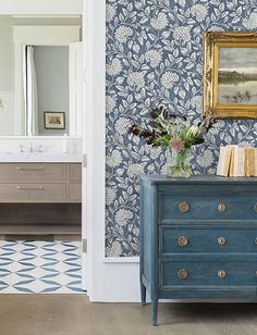 a blue dresser sitting in front of a mirror