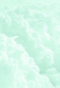 the sky is filled with fluffy clouds and green hued colors, as well as an airplane