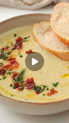 a bowl of soup with bread on the side