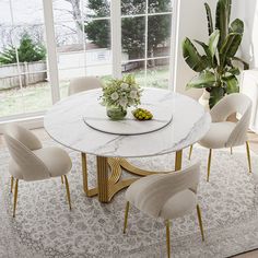 a dining room table with white chairs and a potted plant on top of it