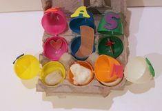 an egg carton filled with lots of toys like eggs and spoons, salt and pepper shakers