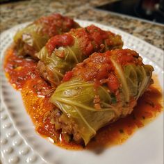 cabbage stuffed with meat and marinara sauce on a white plate