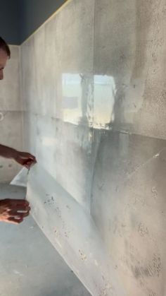 a man is painting a wall with white paint