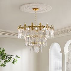 a chandelier hanging from the ceiling in a room with white walls and windows