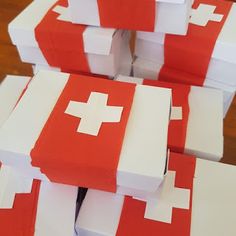 several red and white boxes stacked on top of each other with the swiss flag painted on them