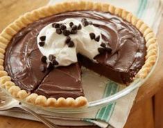 a chocolate pie with whipped cream and chocolate sprinkles on top, ready to be eaten