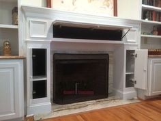 a white fireplace with built in cabinets and shelves