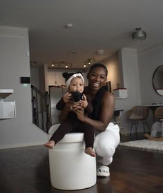 a woman holding a baby sitting on top of a toilet