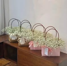 three small bags with flowers in them sitting on a table