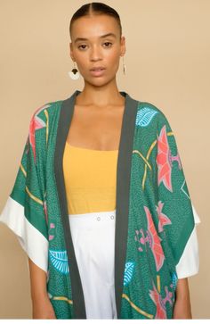 Elegant and striking, our Dhana Kimono is the perfect layer for summer days and effortless style. Throw it over a dress, jeans, or even a swimsuit, wear it on a night out, at the beach, or in the comfort of your home. The print on our Kimono is inspired by traditional Kanga textiles and is digitally printed. Made from 100% Rayon, a natural fibre, this Kimono is One Size and it is made in South Africa. We collaborated with a few local brands based in South Africa to create these special looks: Qi Dress Jeans, Natural Fibre, Woven Bag, White Pants, Natural Fibers, Summer Days, At The Beach, Effortless Style, South Africa