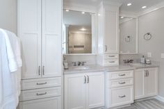 a large bathroom with white cabinets and marble counter tops, along with a gray rug on the floor