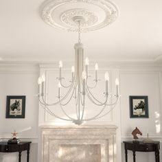 a chandelier hanging from the ceiling in a room with white walls and furniture